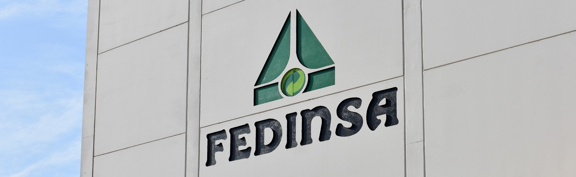 Logotipo FEDINSA en relieve sobre una fachada de la fábrica.