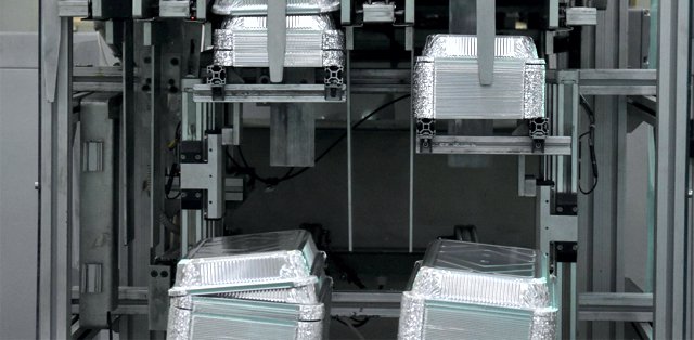 Recipientes de alumínio Fedinsa empilhados na máquina de fabricação.
