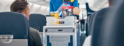 Hôtesse de l'air au service d'un passager.